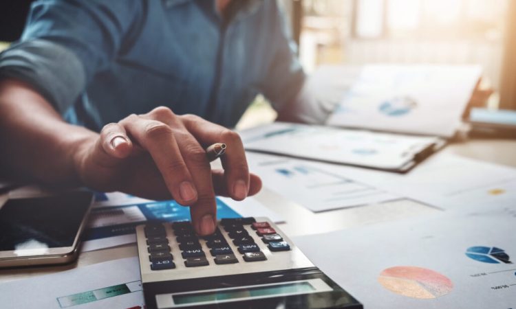 Business accounting concept, Business man using calculator with computer laptop, budget and loan paper in office.